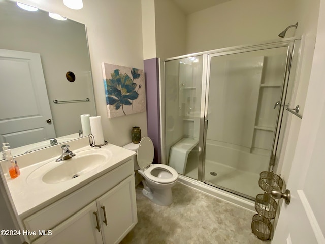 bathroom featuring vanity, an enclosed shower, and toilet