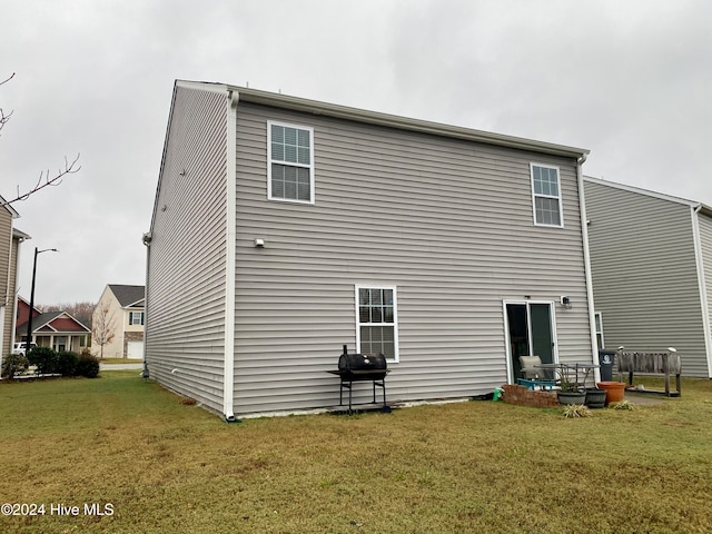 rear view of property featuring a lawn