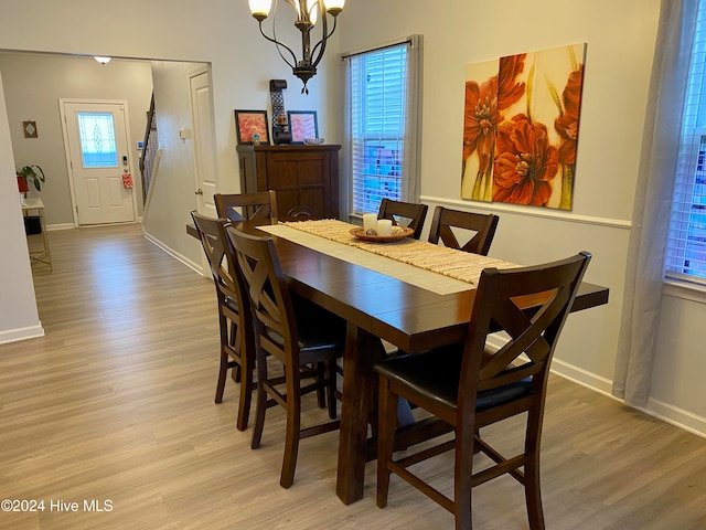 dining space with plenty of natural light, light hardwood / wood-style floors, and a chandelier