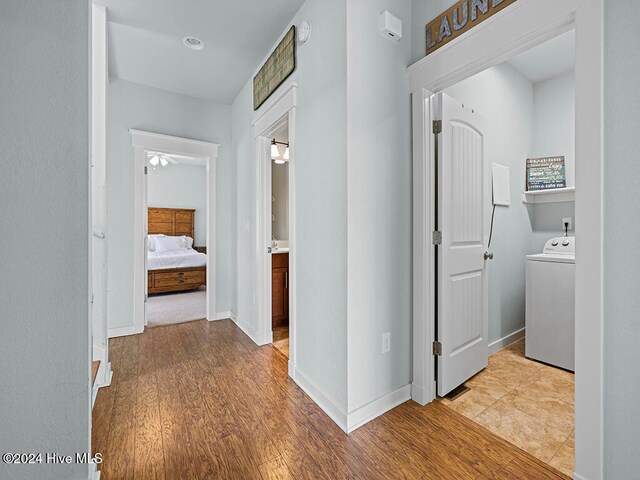 hallway featuring light hardwood / wood-style floors and washer / dryer