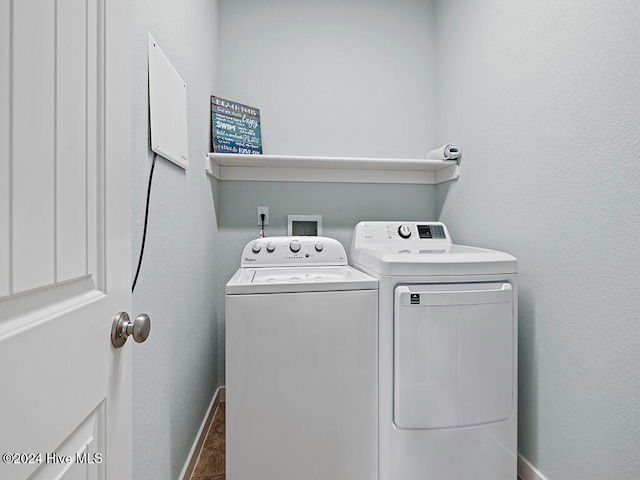 laundry room featuring washer and clothes dryer and dark tile patterned floors