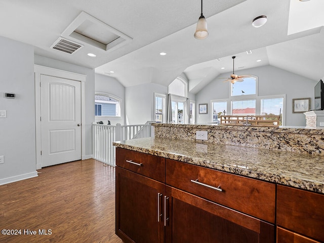 kitchen with dark hardwood / wood-style floors, a healthy amount of sunlight, light stone counters, and lofted ceiling