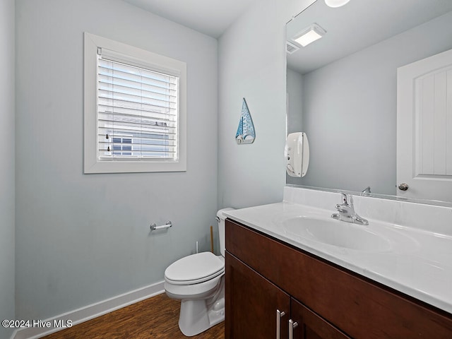 bathroom with hardwood / wood-style floors, vanity, and toilet