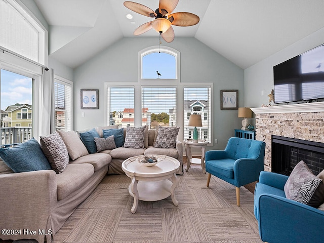 living room featuring ceiling fan, a fireplace, and high vaulted ceiling