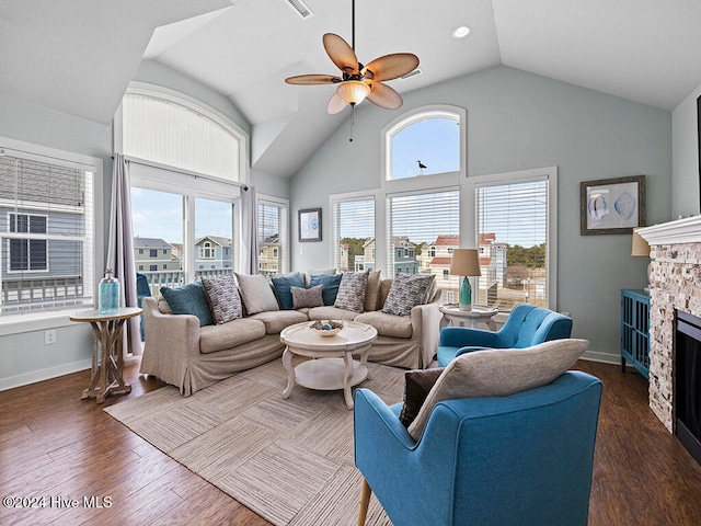 living room with ceiling fan, dark hardwood / wood-style flooring, a fireplace, and high vaulted ceiling