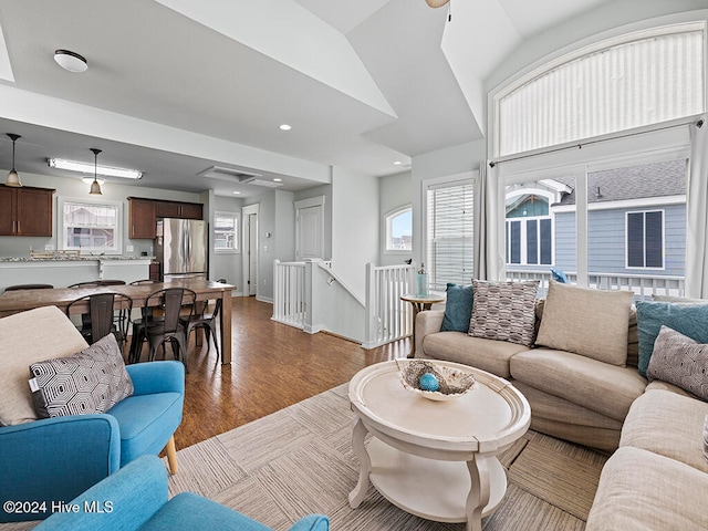 living room with ceiling fan, light hardwood / wood-style floors, and lofted ceiling