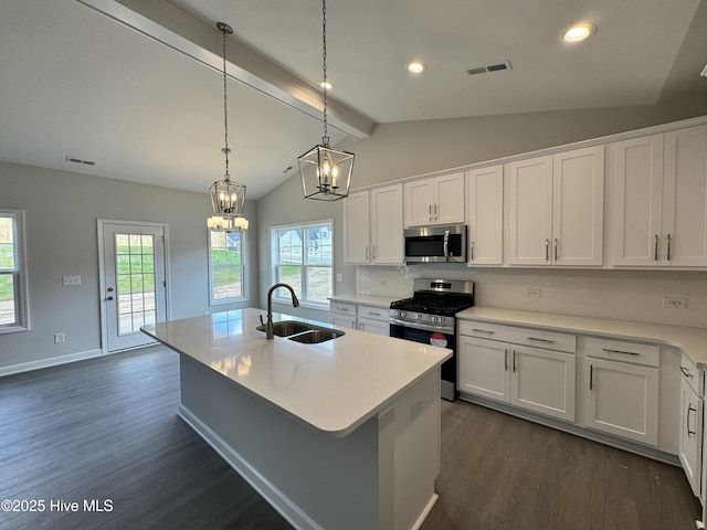 kitchen featuring a sink, stainless steel appliances, dark wood-type flooring, and vaulted ceiling with beams