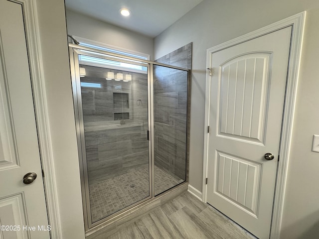 bathroom with a stall shower, baseboards, and recessed lighting