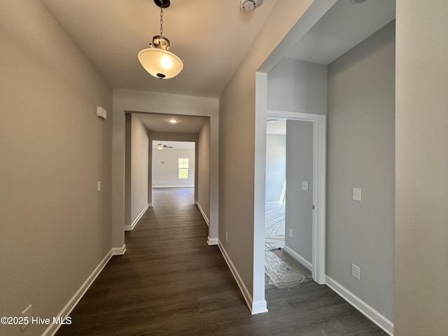 hallway with baseboards and dark wood-style flooring