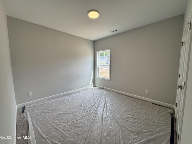 spare room with baseboards and visible vents