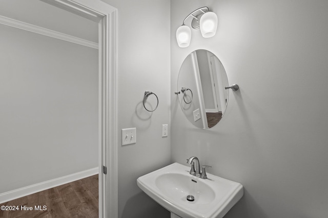 bathroom with ornamental molding, hardwood / wood-style floors, and sink