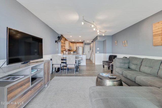 living room featuring light wood-type flooring and rail lighting