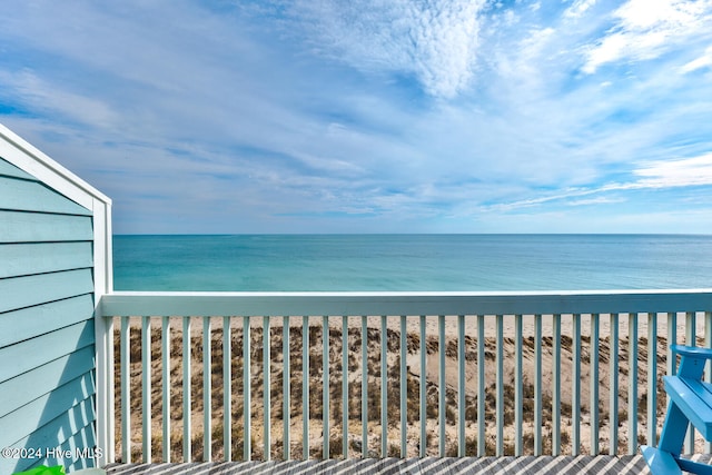 balcony with a water view and a view of the beach