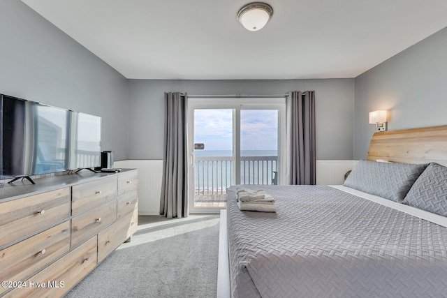 bedroom with access to outside, a water view, and light colored carpet