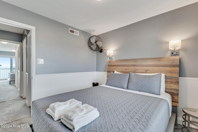 carpeted bedroom featuring wood walls