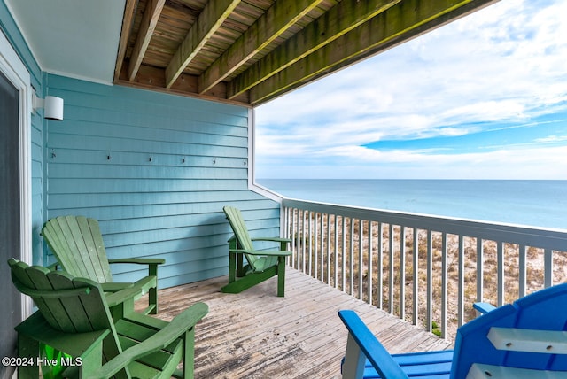 balcony with a deck with water view and a view of the beach