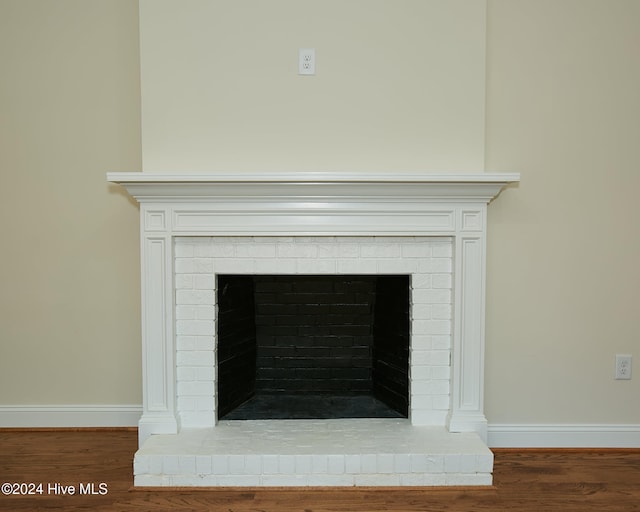 room details featuring wood-type flooring and a brick fireplace