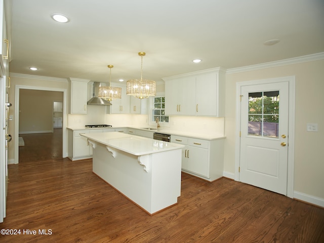 kitchen featuring white cabinetry, a center island, wall chimney exhaust hood, dark hardwood / wood-style floors, and decorative light fixtures