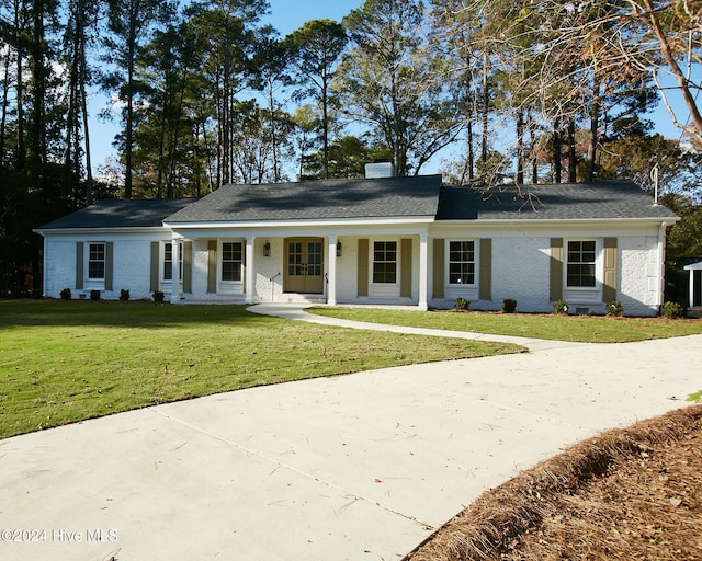 single story home featuring covered porch and a front yard