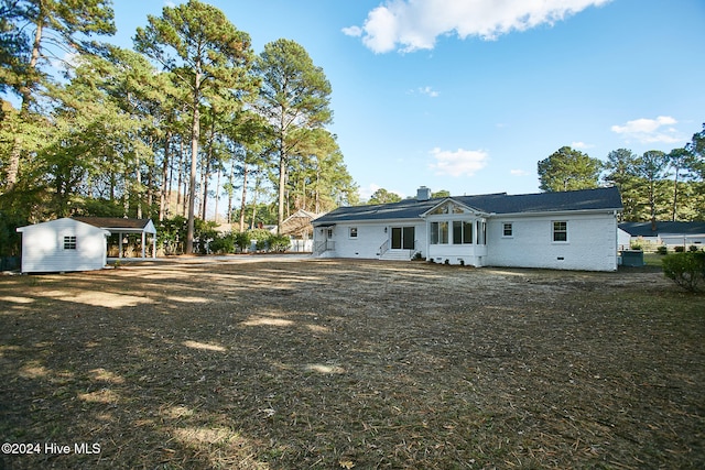 rear view of property featuring a shed