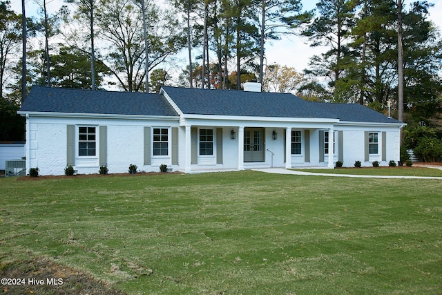 view of front of property featuring covered porch, central air condition unit, and a front lawn