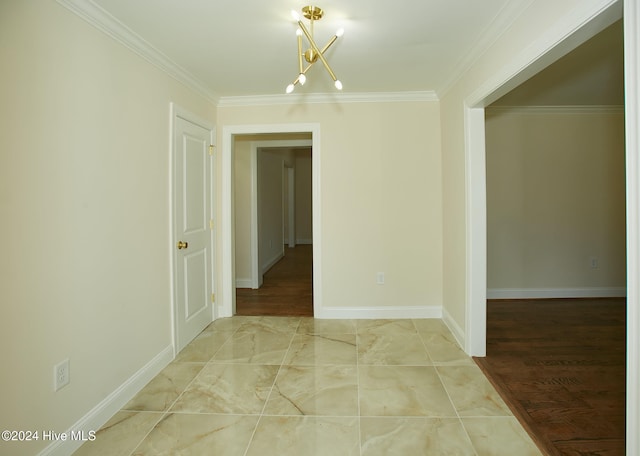 empty room featuring wood-type flooring, a notable chandelier, and ornamental molding