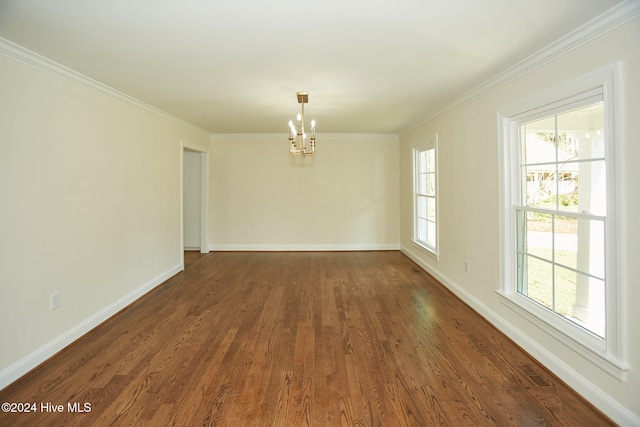 unfurnished room featuring a notable chandelier, dark wood-type flooring, and a wealth of natural light