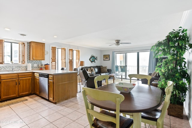 kitchen with dishwasher, backsplash, sink, light tile patterned floors, and kitchen peninsula