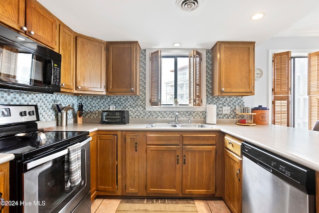 kitchen with decorative backsplash, light tile patterned flooring, sink, and stainless steel appliances