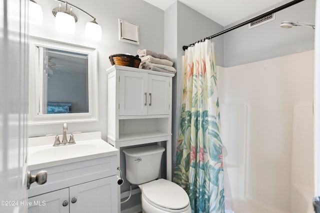 bathroom featuring toilet, vanity, and walk in shower