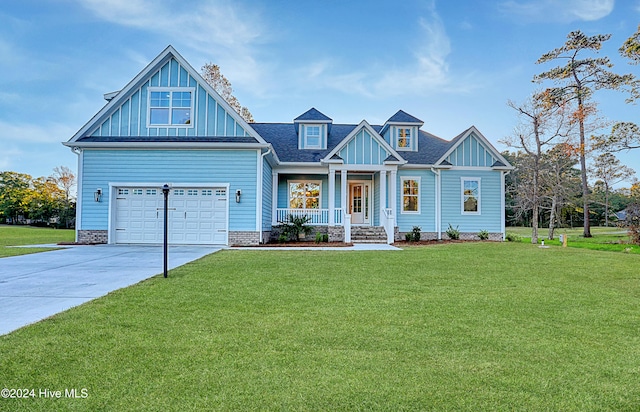 craftsman-style home with a garage, covered porch, and a front yard