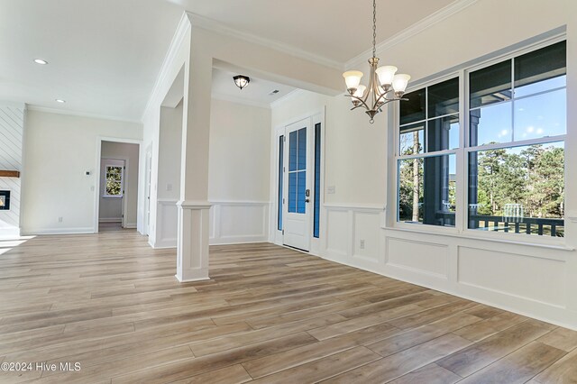 unfurnished dining area with wood-type flooring, crown molding, and a healthy amount of sunlight