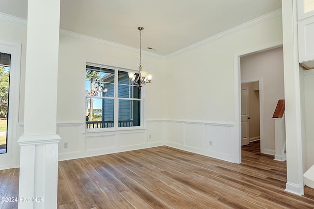 115 Genoes Point Rd SW, Supply, NC 28462 - unfurnished dining area featuring light wood-type flooring, crown molding, a chandelier, wainscoting, and ornate columns