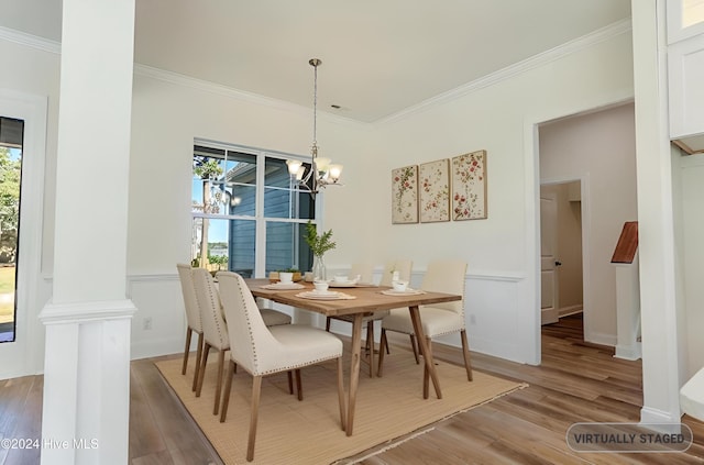 dining room featuring hardwood / wood-style floors, crown molding, a wealth of natural light, and an inviting chandelier