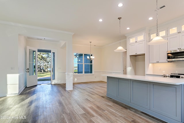 kitchen with light hardwood / wood-style floors, white cabinetry, ornamental molding, and appliances with stainless steel finishes