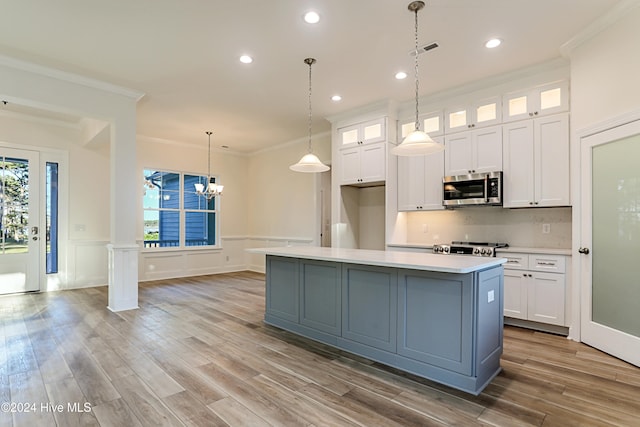 kitchen featuring white cabinets, appliances with stainless steel finishes, light hardwood / wood-style floors, and an island with sink