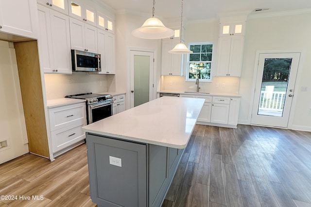 115 Genoes Point Rd SW, Supply, NC 28462 - kitchen featuring stainless steel appliances, ornamental molding, light wood-type flooring, light countertops, and a kitchen island