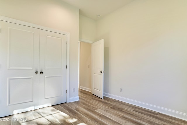 unfurnished bedroom featuring light hardwood / wood-style flooring and a closet