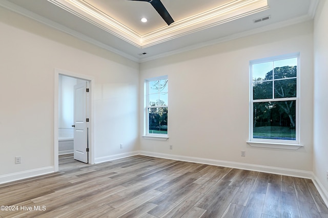 spare room with crown molding, plenty of natural light, and light wood-type flooring