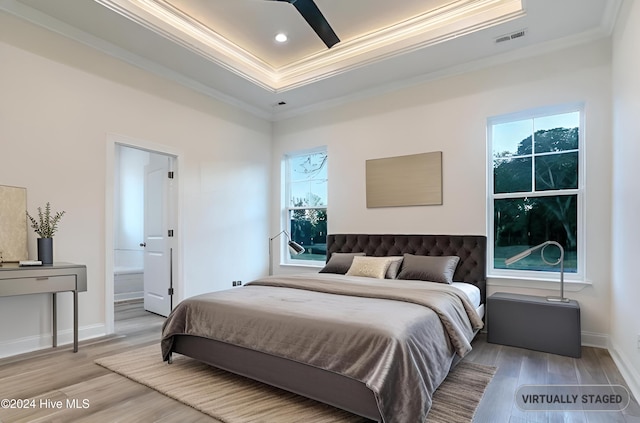 bedroom featuring multiple windows, hardwood / wood-style floors, ensuite bathroom, and ceiling fan