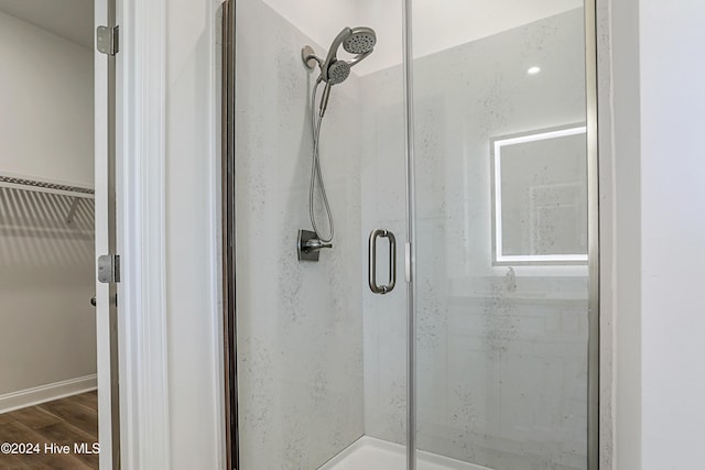 bathroom with hardwood / wood-style floors and a shower with door