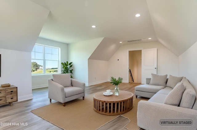 living room with light hardwood / wood-style floors and lofted ceiling