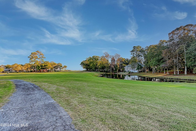 surrounding community with a yard and a water view