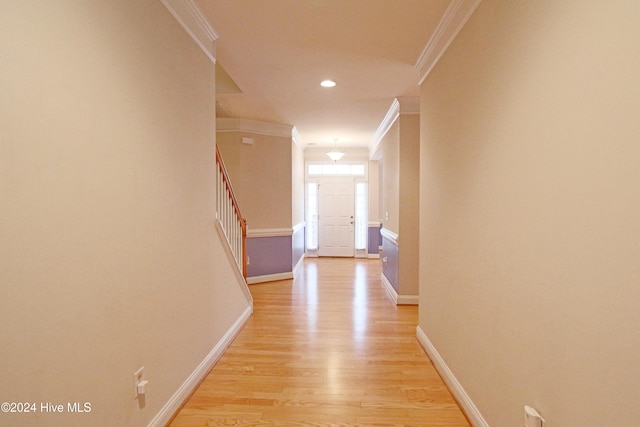 corridor with ornamental molding and light wood-type flooring