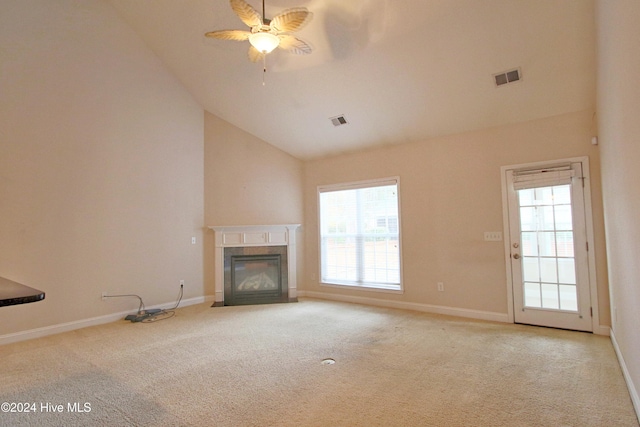 unfurnished living room featuring ceiling fan, plenty of natural light, high vaulted ceiling, and light colored carpet