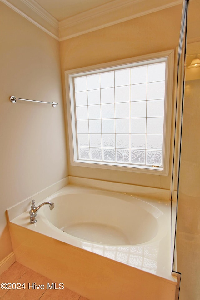 bathroom with a tub to relax in, tile patterned flooring, and ornamental molding