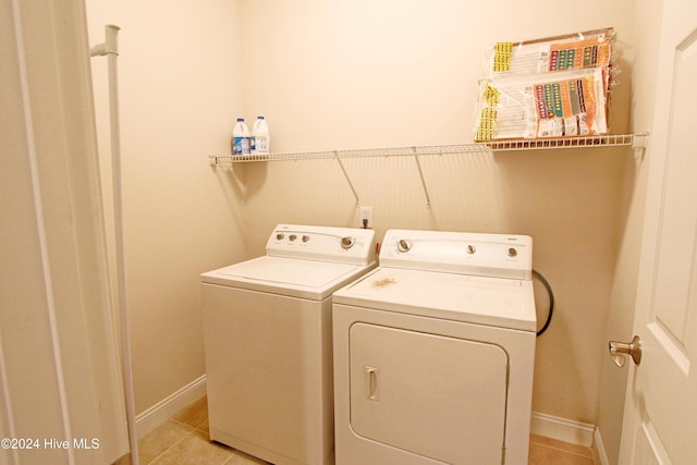 laundry area featuring light tile patterned floors and washing machine and clothes dryer