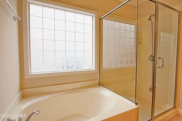 bathroom featuring shower with separate bathtub