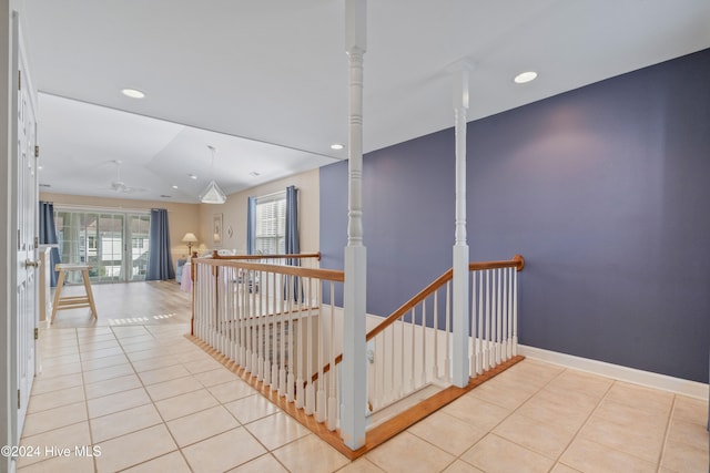 hallway featuring lofted ceiling and light tile patterned floors