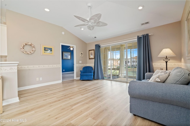 living room with ceiling fan, vaulted ceiling, and light wood-type flooring